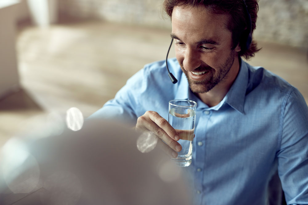 Person hält ein Glas Wasser.